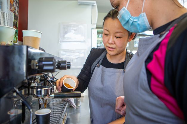 A catering instructor teaches a woman in prison how to make coffee at Auckland Region Womens Corrections Facility